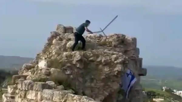 Defiant Act: Lebanese Man Tears Down Israeli Flag from Historic Castle in Southern Lebanon